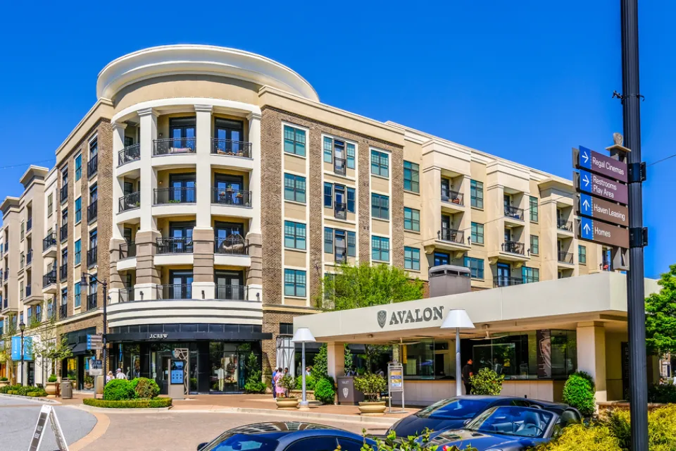 A mid-rise building with retail and apartments. A car port announces the name of the development: Avalon.